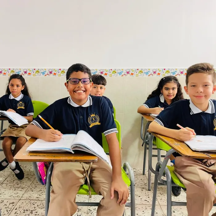 Estudiantes del Gimnasio Campestre en sus pupitres con libros abiertos