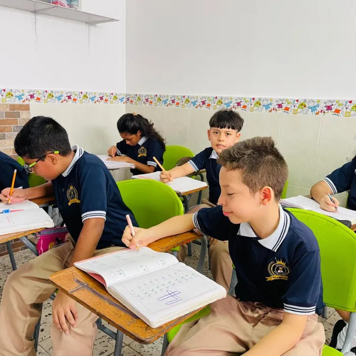 Estudiantes del Gimnasio Campestre trabajando en sus cuadernos dentro del aula